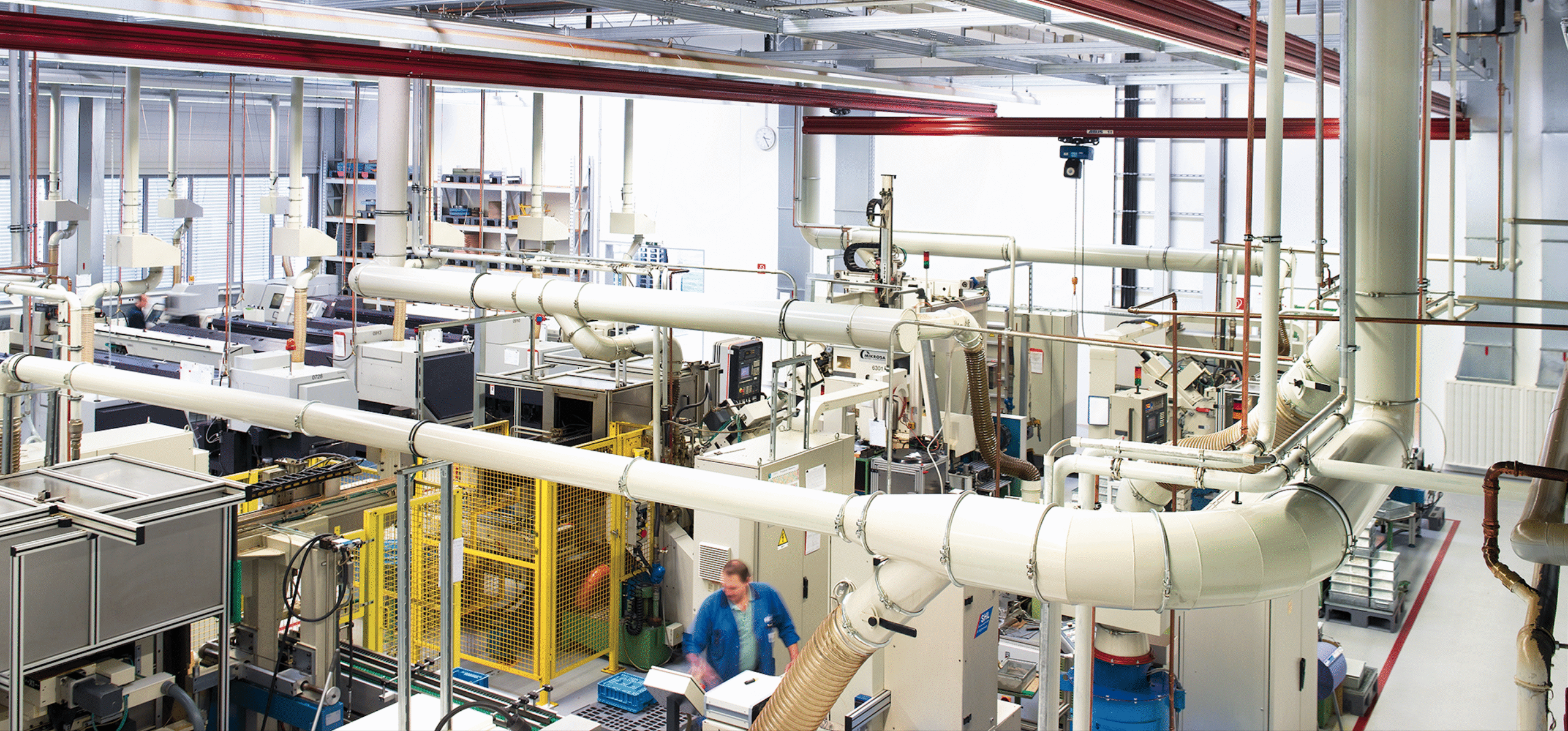 Průmyslová výrobní hala s automatizovanými potrubními systémy v moderní továrně